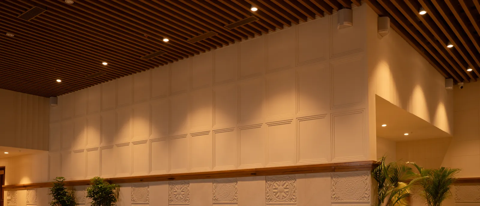 Restaurant wall with carved panels and timber-slat ceiling — Chalukya Samrat